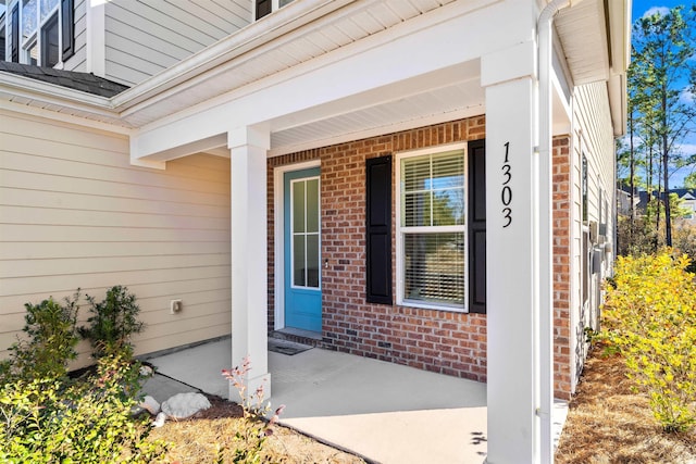 view of exterior entry featuring covered porch