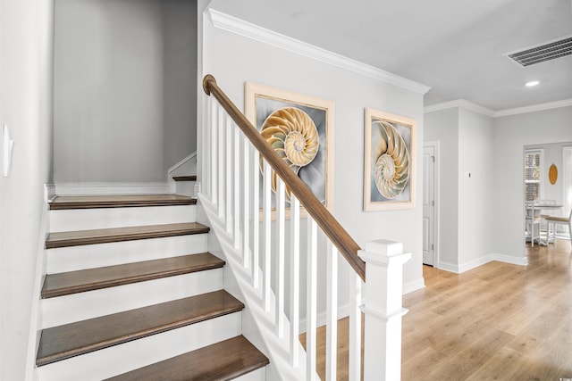 stairway with crown molding and wood-type flooring