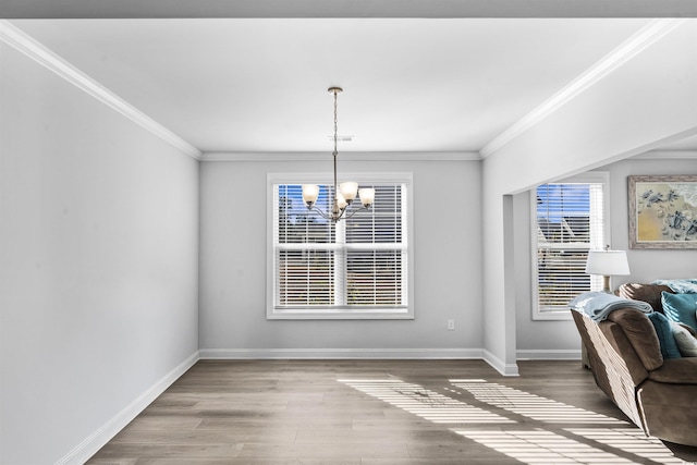 dining space with an inviting chandelier, ornamental molding, and hardwood / wood-style floors