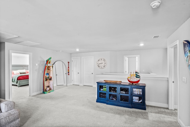 recreation room with light colored carpet