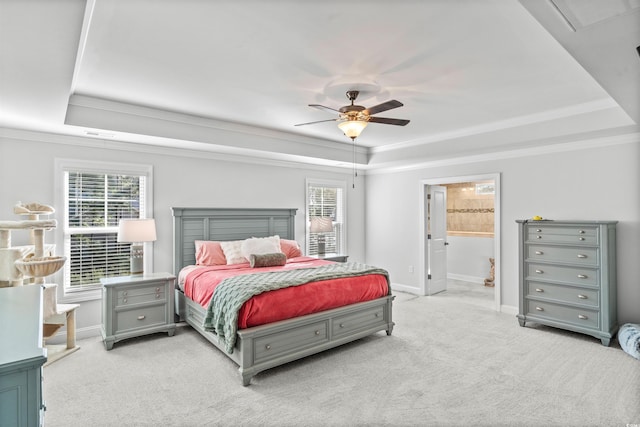 bedroom featuring multiple windows, ornamental molding, light carpet, and a tray ceiling