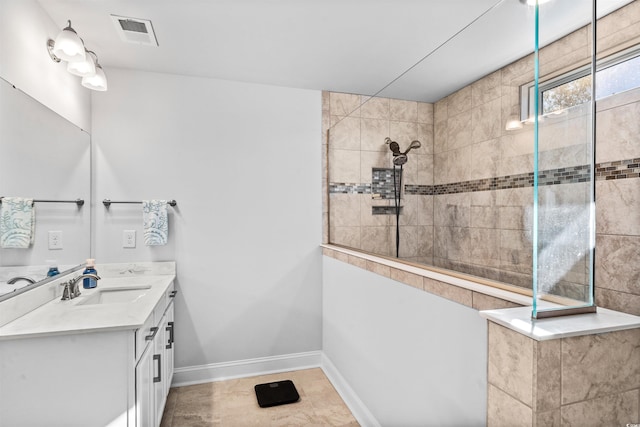 bathroom with vanity and a tile shower