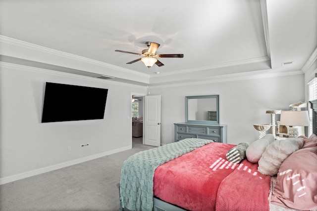 carpeted bedroom featuring a raised ceiling, ornamental molding, and ceiling fan