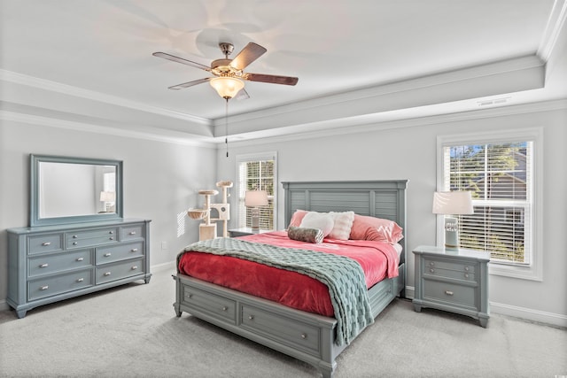 bedroom with multiple windows, ornamental molding, a raised ceiling, and light carpet