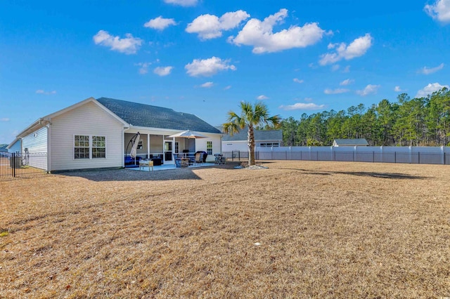 back of property with a lawn and a patio