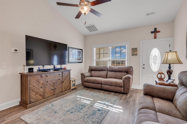 living room with ceiling fan, lofted ceiling, and light wood-type flooring