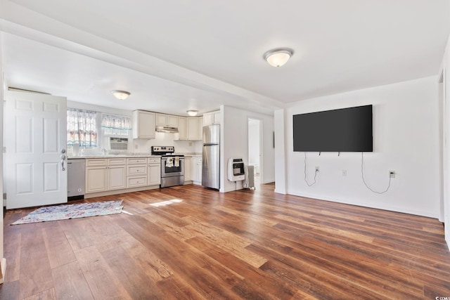 kitchen featuring cream cabinetry, stainless steel appliances, and dark hardwood / wood-style floors