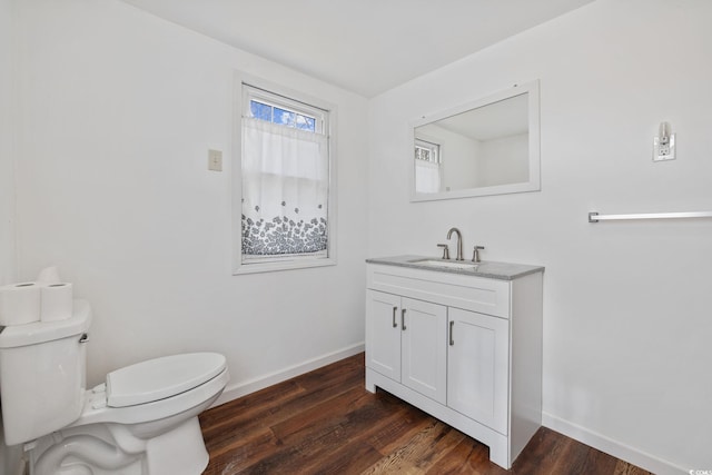 bathroom with wood-type flooring, vanity, and toilet