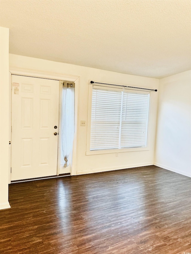 entrance foyer featuring dark wood-type flooring and a textured ceiling