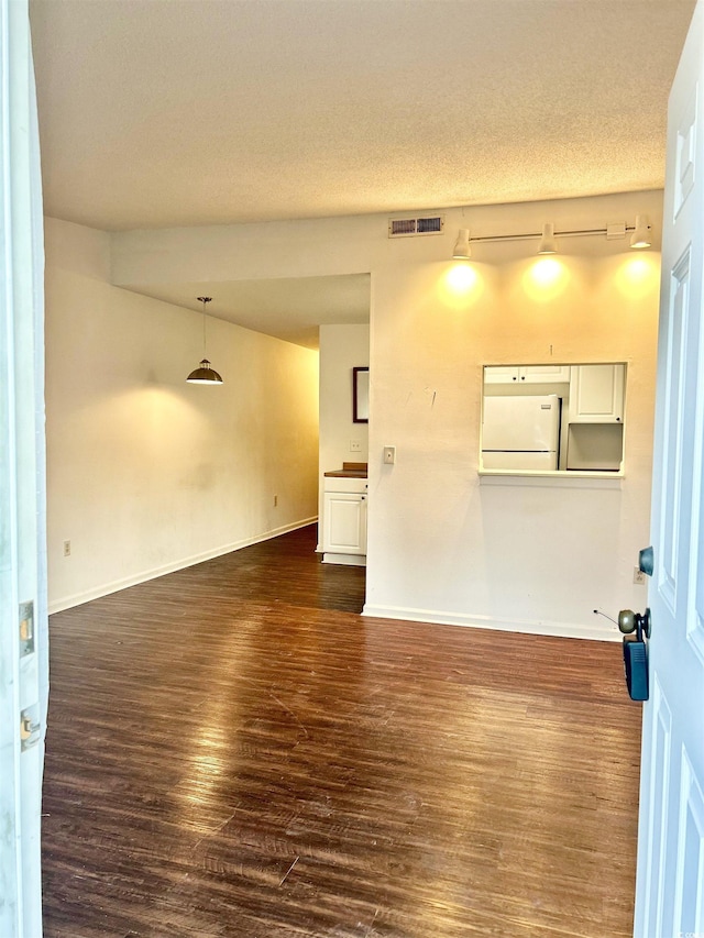 unfurnished room with dark hardwood / wood-style floors and a textured ceiling