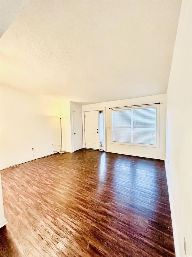 unfurnished living room featuring wood-type flooring and a textured ceiling