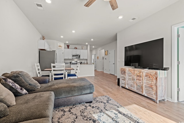 living room featuring light hardwood / wood-style floors and ceiling fan