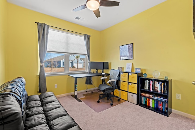 carpeted office space featuring ceiling fan