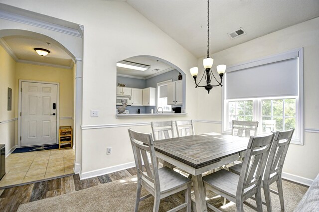 6015 Catalina Dr Unit 431, North Myrtle Beach, SC 29582 - dining space with a notable chandelier, baseboards, visible vents, wood finished floors, and arched walkways