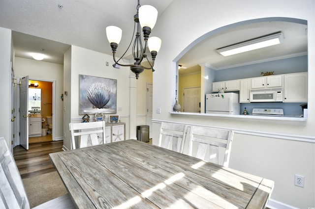 6015 Catalina Dr Unit 431, North Myrtle Beach, SC 29582 - dining space featuring dark wood-style flooring, baseboards, arched walkways, a chandelier, and ornamental molding