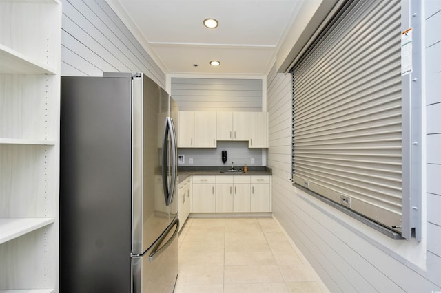 6015 Catalina Dr Unit 431, North Myrtle Beach, SC 29582 - kitchen featuring a sink, freestanding refrigerator, light tile patterned flooring, wooden walls, and dark countertops