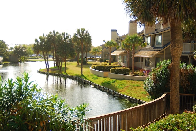 surrounding community with a water view and a yard