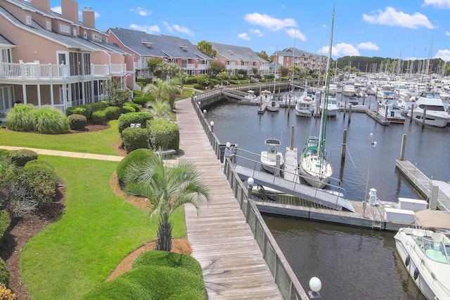 view of dock featuring a lawn and a water view