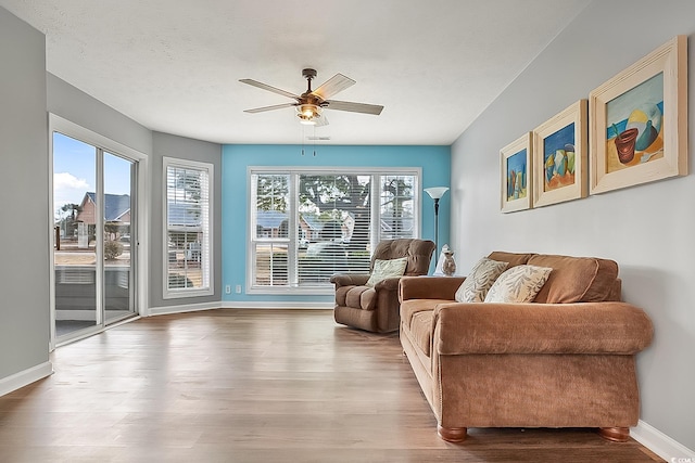 living area with hardwood / wood-style floors, a textured ceiling, and ceiling fan