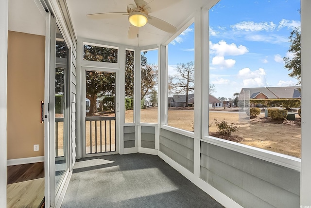 unfurnished sunroom with ceiling fan