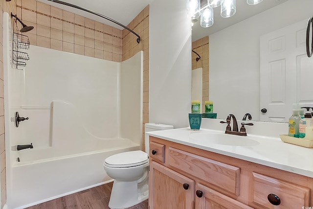 full bathroom featuring vanity, tiled shower / bath combo, wood-type flooring, and toilet