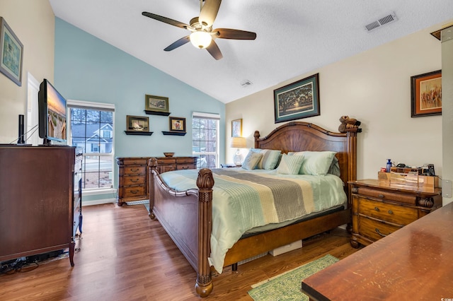 bedroom with lofted ceiling, a ceiling fan, visible vents, and dark wood-style flooring