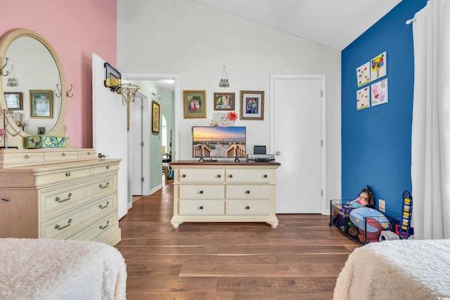 bedroom with dark wood-type flooring and lofted ceiling