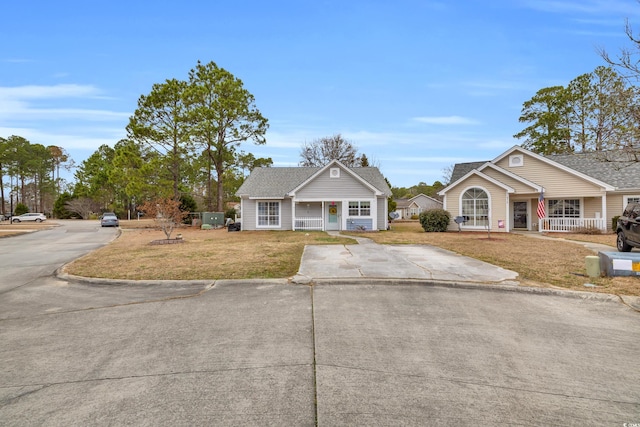 6716 Wisteria Dr, Myrtle Beach, SC 29588 - bungalow-style house featuring a front lawn, covered porch, roof with shingles, and concrete driveway