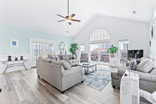 living area featuring high vaulted ceiling, wood finished floors, visible vents, and a ceiling fan