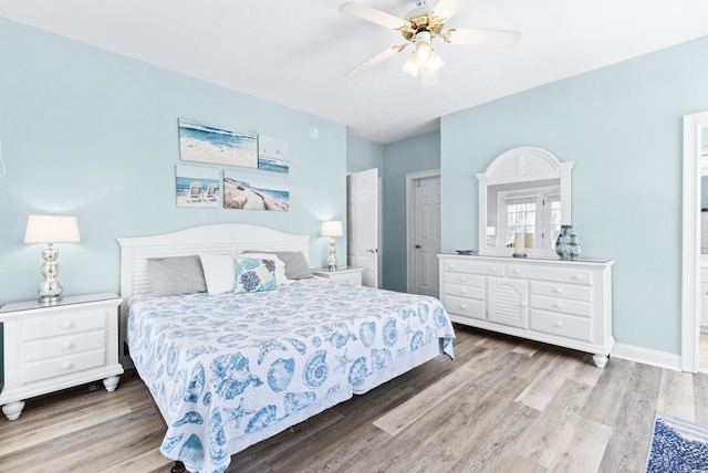 bedroom with wood finished floors, a ceiling fan, and baseboards