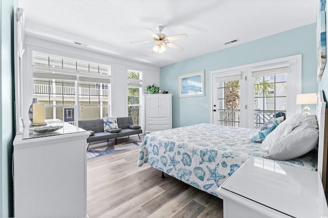 bedroom featuring access to exterior, visible vents, and multiple windows