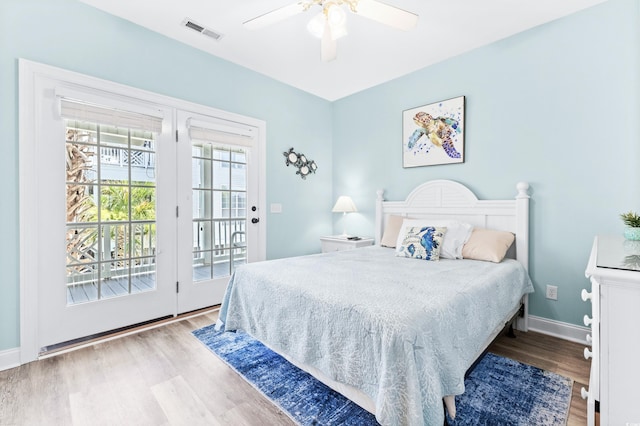 bedroom featuring access to outside, wood finished floors, visible vents, and baseboards