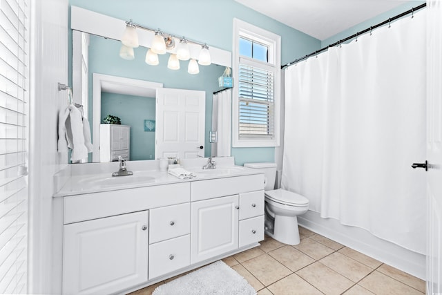 full bath with double vanity, a sink, toilet, and tile patterned floors