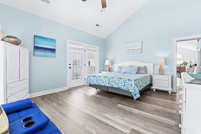 bedroom featuring access to exterior, wood finished floors, visible vents, and multiple windows