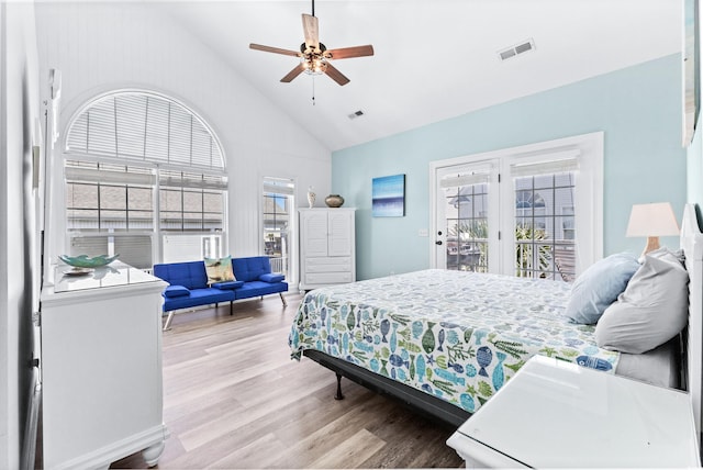 bedroom featuring high vaulted ceiling, access to outside, wood finished floors, and visible vents