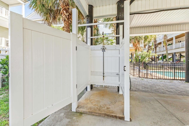 view of gate featuring fence and a fenced in pool