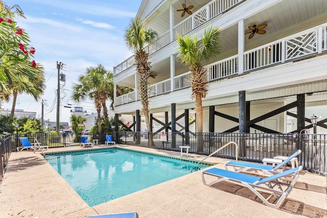 pool with fence, a patio, and ceiling fan