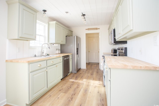 kitchen featuring butcher block counters, sink, stainless steel appliances, and light hardwood / wood-style floors