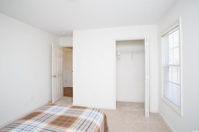 unfurnished bedroom with light colored carpet and a closet