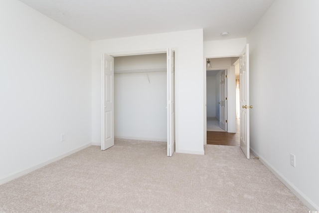 unfurnished bedroom with light carpet and a closet