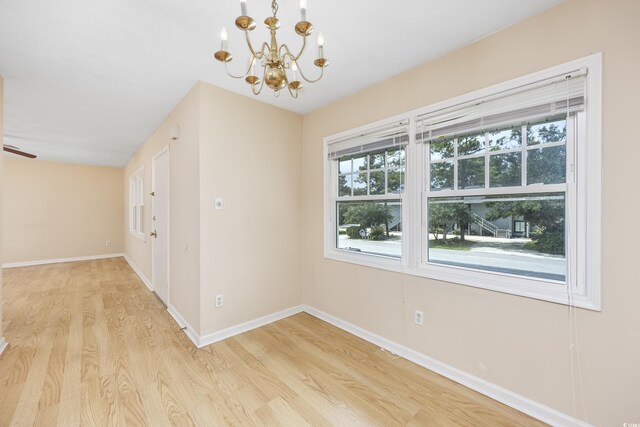 7602 Porcher Dr Unit C, Myrtle Beach, SC 29572 - unfurnished room with baseboards, light wood-type flooring, and a notable chandelier
