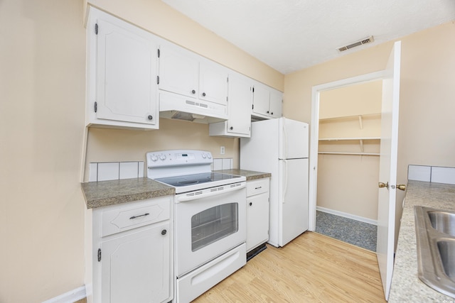 7602 Porcher Dr Unit C, Myrtle Beach, SC 29572 - kitchen with white cabinetry, light wood-type flooring, white appliances, under cabinet range hood, and visible vents