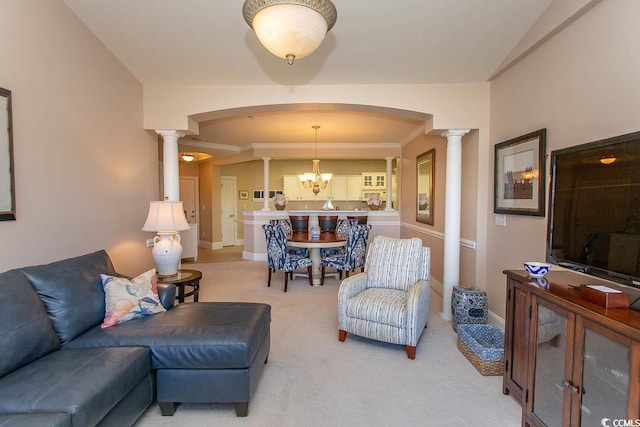 living room featuring decorative columns, carpet flooring, and an inviting chandelier