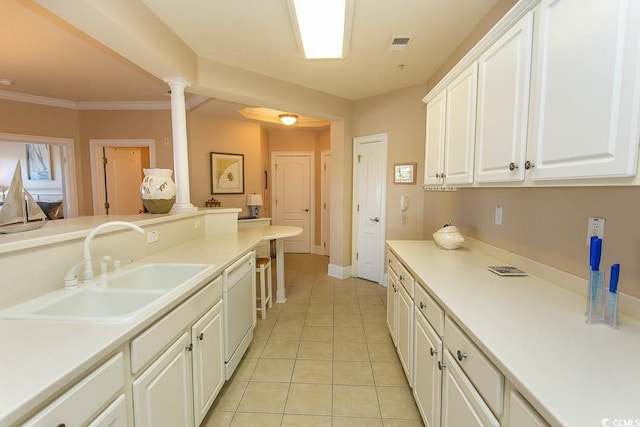 kitchen featuring sink, decorative columns, white dishwasher, white cabinets, and light tile patterned flooring