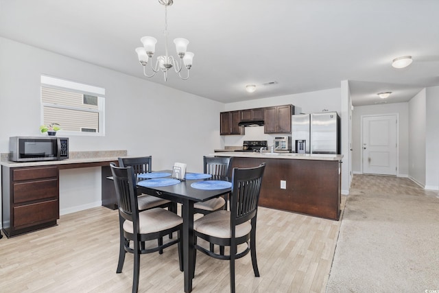 dining space with an inviting chandelier and light wood-type flooring