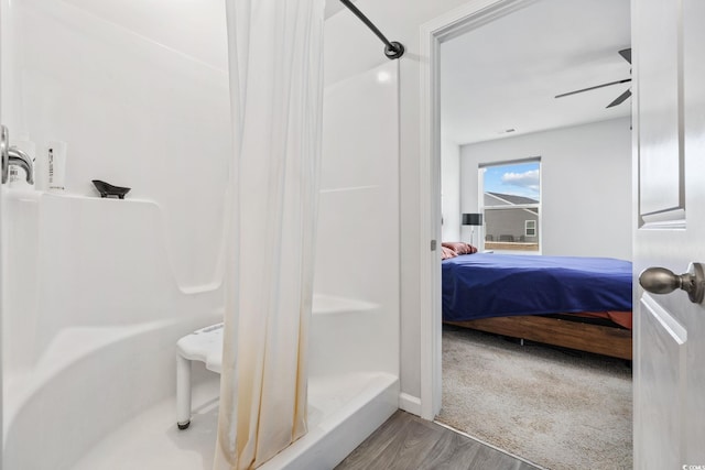 bathroom with hardwood / wood-style floors, ceiling fan, and a shower with shower curtain