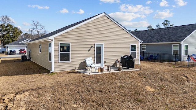 rear view of house with cooling unit, a yard, and a patio area