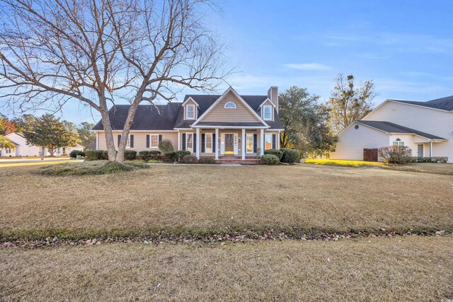 cape cod home featuring a front lawn and covered porch