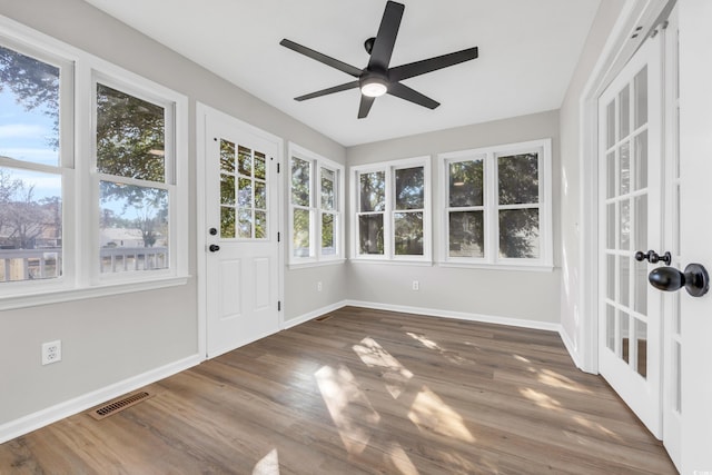 unfurnished sunroom featuring visible vents and a ceiling fan