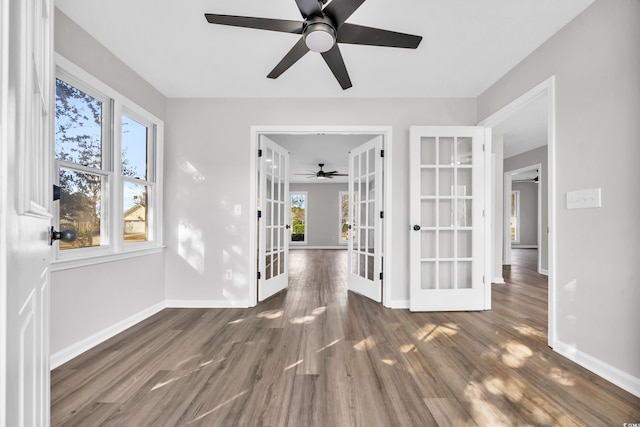 spare room with french doors, wood finished floors, and baseboards